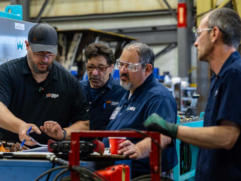 Men wearing safety glasses looking at paperwork